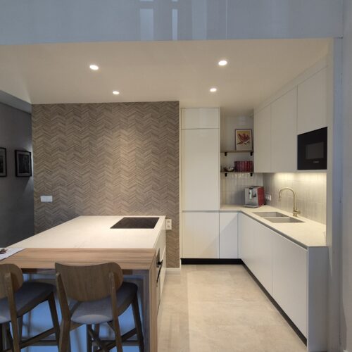 Cuisine ouverte rénovée à Lyon 9 avec plan de travail en stratifié compact et papier peint décoratif.